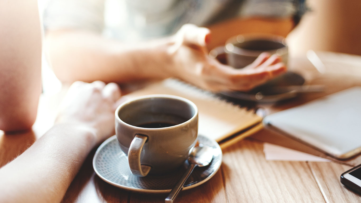 Zwei Kaffeetassen auf Tisch, braunes Holz, Unterlagen